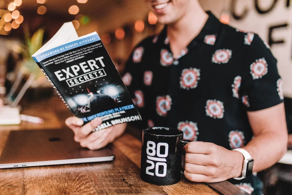 Man reading a marketing book with coffee