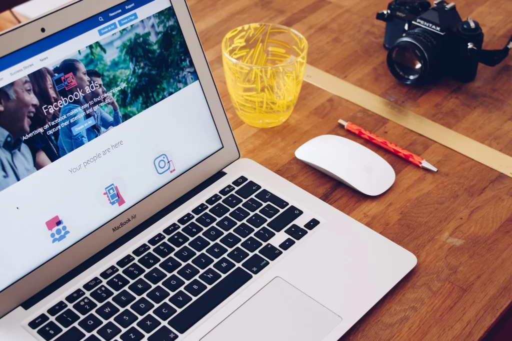 Laptop showing Facebook ads on a desk