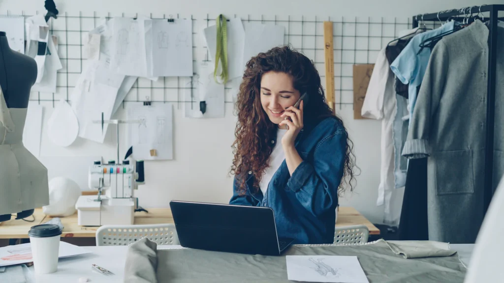 Small business owner talking on the phone at her laptop