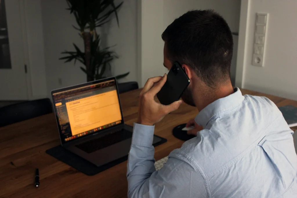Man on a phone call at his laptop